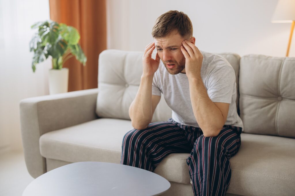 Depressed hopeless man in home wear lying on sofa during mental breakdown, psychotherapy, banner